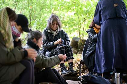A group of people sitting on chairs outside.