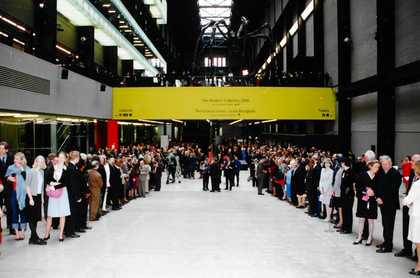 A crowd of people, including Her Majesty the Queen, inside the Turbine Hall at Tate Modern's opening.