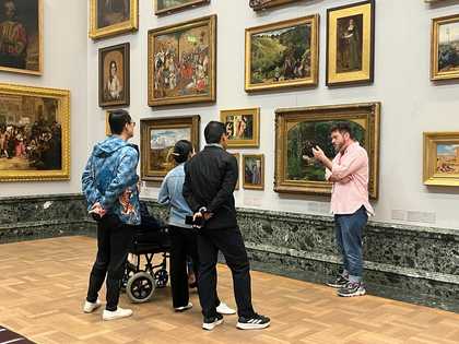 Person talking to a group of people in a gallery.