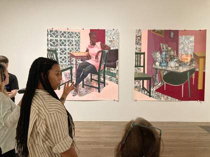 A group of people in front of two paintings