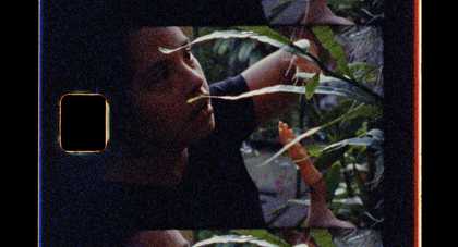 negetive film image where a person looks at a plant