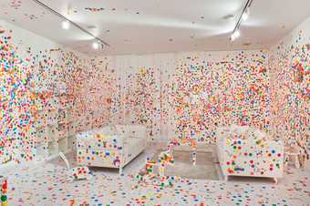 White room with two white sofa covered in bright dots
