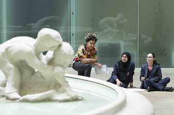 Artist explores art work in the Tate Modern Turbine Hall with two students