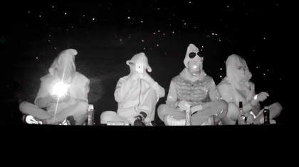 A still from a film showing people sat in a row in the dark.