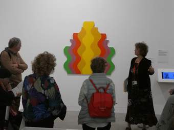 A group of three people listening to a talk by specialist gallery educator Susanna Webster