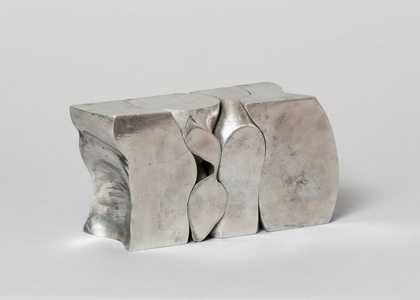A silver sculpture, shaped like a segmented block, against a white background