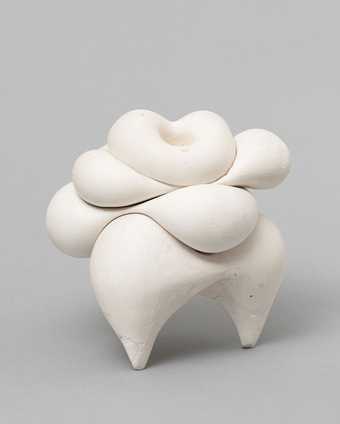 A white sculpture, with voluptuous bulging layers, against a white background
