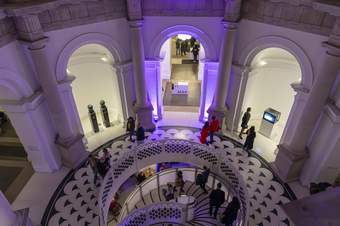 People walking around a staircase and archways in Tate Britain, viewed from above