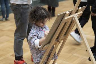 A child drawing using an easel in the gallery