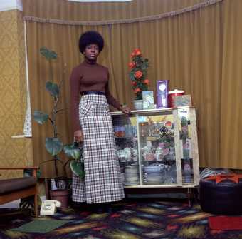 Neil Kenlock Young Jamaican Lady Standing in her Mother’s Front Room in Brixton Hill 1973