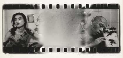 black and white image of negetive film still showing two people in a bathroom with off cuts of hair on their bodies and head