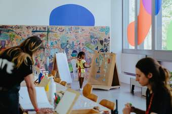 A girl paints at an easel in Paint Room at Tate Britain