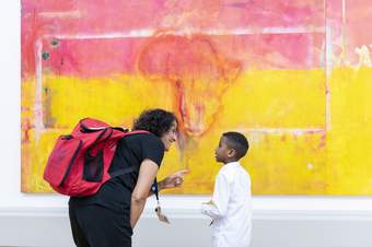 A teacher and a student looking at a colourful artwork together