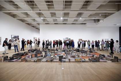 People standing in front of artwork consisting of patterned blocks arranged on the floor
