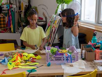 Two girls play with fabric in a studio at Tate Britain