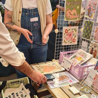 a stall with colourful illustrated prints, stickers and cards