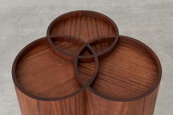 the top of three cyclinders in a dark mahogany wood which overlap to create a trinity symbol