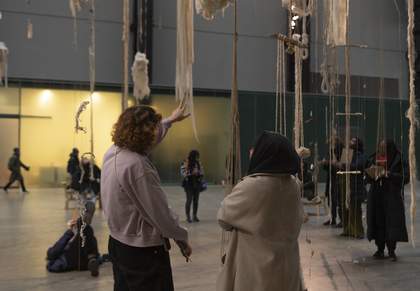 Group of teachers looking up at a large mixed media hanging artwork in a hall at Tate.