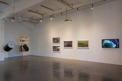White-walled gallery space with a number of framed artworks on the walls
