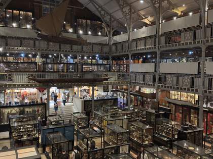 An image of a multi-storey museum hall lined with cabinets and display cases exhibiting a variety of artefacts.