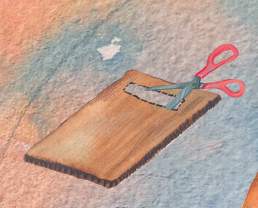 Scissors cut into a piece of cardboard, with a rectangular section cut out