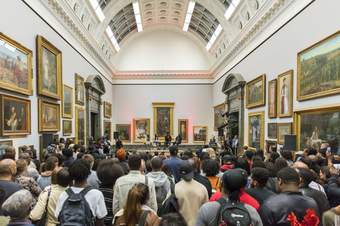 A large group of people listening to a talk in a gallery in Tate Britain