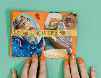 Two hands with orange fingernails holding a small collage of images with the words Be Yourself