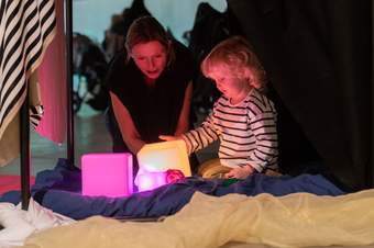 A parent and child looking at lights in an art workshop