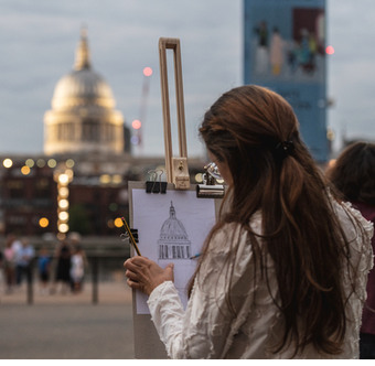Person standing in front of an easel sketching St Paul's Cathedral