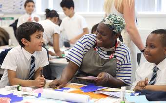 A photograph of two schoolchildren with artist Victoria Opomu