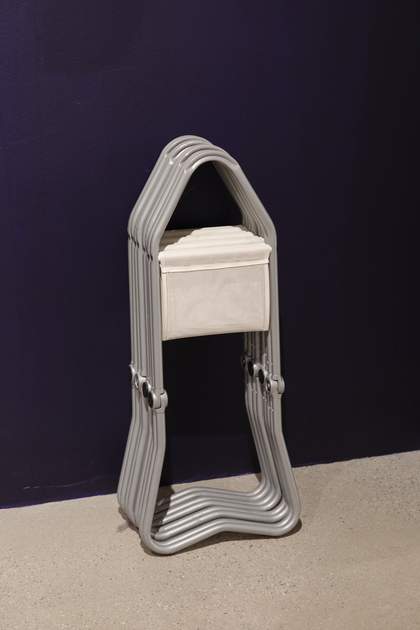 A set of folding stools leaning against a wall.
