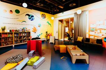 Bright reading room with bookshelves, colorful seating, and creative wall art.