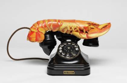 a lobster on top of a black old fashioned telephone