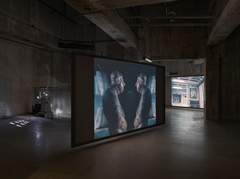 Photo of a large room with Rosa Barba films displayed on screens