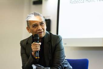 A photograph of artist Lubaina Himid holding a microphone