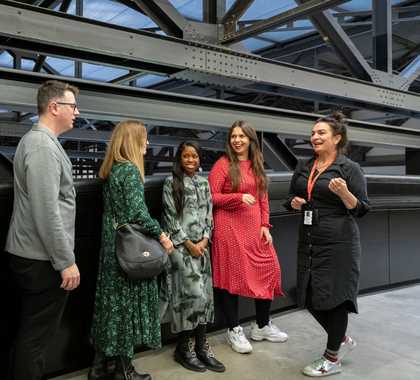 A group of five people talking at Tate Modern