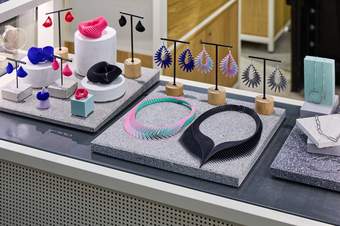 Colourful jewellery, including necklaces and earrings, laid out on a shop table