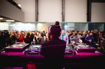 A DJ plays as people dance in the Turbine Hall