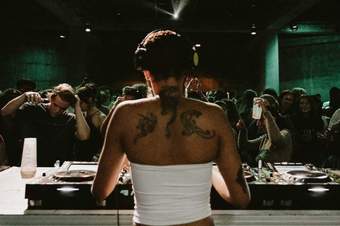The back of a DJ looking out onto a crowd