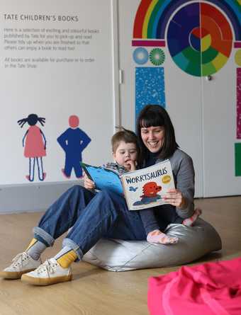 A boy and his mum sit reading a book