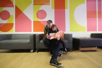 Child and dad reading with sketchbook in Tate Liverpool's Clore Studio
