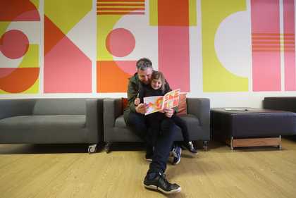 Child and dad reading with sketchbook in Tate Liverpool's Clore Studio