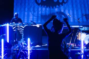 A person dancing to a DJ set in Tate Modern's South Tank venue. The lighting is florescent blue.