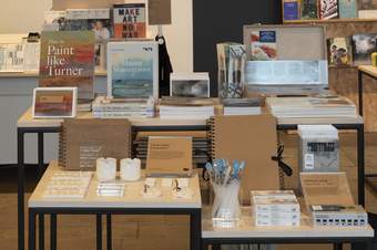 A photograph of books and painting equipment in the Tate Liverpool shop.