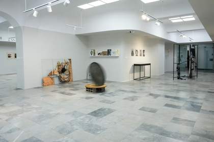 A metal pan on static display in the center of a gallery space.