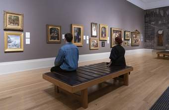 People sitting on a bench in an art gallery
