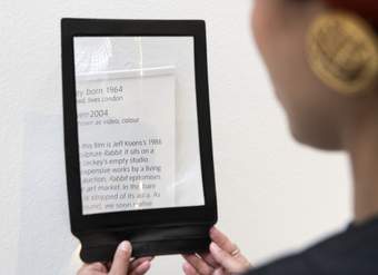 A person looking at text through a rectangular magnifier