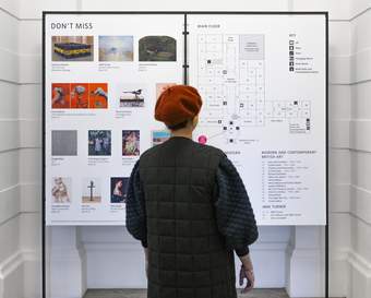 A person looking at a large gallery map