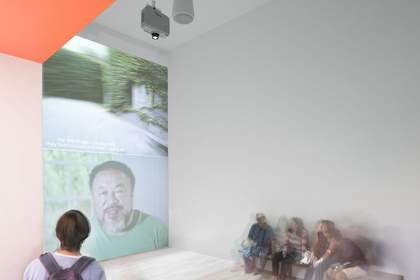 Man looks onto a wall where Ai Weiwei's face is being projected