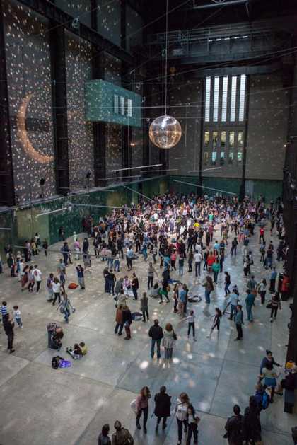 Disco ball and lights fills the turbine hall with dancers and visitors
